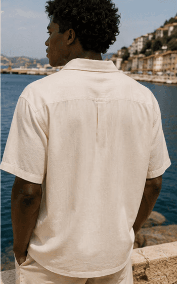 Man in cream linen shirt by the harbor